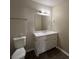 Bathroom with single vanity, white cabinets, white countertop, large mirror and dark wood-look flooring at 4735 Jackam Ridge Ct, Lithonia, GA 30038