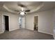 Open main bedroom boasts tray ceiling, ceiling fan, and access to bathroom at 4735 Jackam Ridge Ct, Lithonia, GA 30038