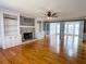 Spacious living room featuring hardwood floors, a fireplace, built-in shelving, and french doors at 2120 Chartwell Ct, Lawrenceville, GA 30043