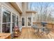 Spacious wooden back deck with a dining set and grill, great for outdoor gatherings, with firewood nearby at 6435 Ivey Creek Cir, Cumming, GA 30040