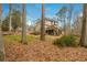 Backyard view of the home with a wooden deck and stairs surrounded by trees at 6435 Ivey Creek Cir, Cumming, GA 30040