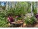 Lush backyard with a fire pit and seating, perfect for enjoying the natural surroundings and peaceful atmosphere at 6435 Ivey Creek Cir, Cumming, GA 30040
