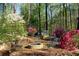 Secluded backyard features a fire pit, surrounded by colorful flowering shrubs, offering a tranquil retreat at 6435 Ivey Creek Cir, Cumming, GA 30040