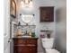 Stylish half-bathroom with dark wood vanity, granite countertop, and decorative mosaic backsplash at 6435 Ivey Creek Cir, Cumming, GA 30040