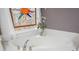 Close up of a garden tub with gold fixtures and a decorative sun-shaped stained-glass window at 6435 Ivey Creek Cir, Cumming, GA 30040