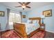 This bright bedroom features a ceiling fan, a window with natural light, and hardwood floors at 6435 Ivey Creek Cir, Cumming, GA 30040