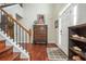 Inviting foyer with hardwood floors, a staircase, and a decorative cabinet at 6435 Ivey Creek Cir, Cumming, GA 30040