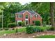 Charming two-story brick home with arched window, black shutters, and a well-maintained, lush landscaped yard at 6435 Ivey Creek Cir, Cumming, GA 30040