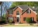 Charming two-story brick home with a welcoming front door, black shutters, and lush green lawn at 6435 Ivey Creek Cir, Cumming, GA 30040