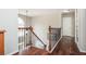 Upstairs hallway features hardwood floors, ornate iron railings, and natural light from the window at 6435 Ivey Creek Cir, Cumming, GA 30040