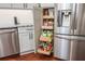 Kitchen showcasing pull-out pantry shelves next to the stainless steel refrigerator at 6435 Ivey Creek Cir, Cumming, GA 30040