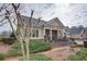 A quaint one-story home with tan siding, brick accents, a cozy front porch, and mature landscaping at 950 Brook Knoll Ln, Cumming, GA 30041