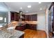Gourmet kitchen featuring stainless steel appliances, dark wood cabinetry, granite countertops, tile backsplash, and hardwood floors at 950 Brook Knoll Ln, Cumming, GA 30041