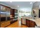 Contemporary kitchen with stainless steel appliances, dark wood cabinetry, granite counters, open to the eating area at 950 Brook Knoll Ln, Cumming, GA 30041