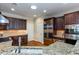 Modern kitchen showcasing stainless steel appliances, dark wood cabinetry, granite countertops, and a skylight at 950 Brook Knoll Ln, Cumming, GA 30041