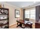 Stylish office with a large desk, wooden shelves, and natural light from the window at 950 Brook Knoll Ln, Cumming, GA 30041