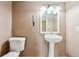 Small bathroom with single white pedestal sink, toilet, and vanity lighting at 2235 Emerald Springs Dr, Decatur, GA 30035