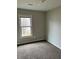 This bedroom features a window with a view of the outdoors and carpet at 304 Deerfield Dr, Jonesboro, GA 30238