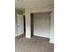 This bedroom features neutral walls, carpet, closet, and an electrical outlet at 304 Deerfield Dr, Jonesboro, GA 30238