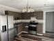 This kitchen features stainless steel appliances, dark cabinets, and laminate flooring at 304 Deerfield Dr, Jonesboro, GA 30238