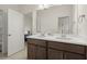 Bathroom featuring a double sink vanity with modern faucets and neutral tiling at 4205 Madison Hall Dr, Cumming, GA 30028