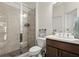Modern bathroom features a glass-enclosed shower, a vanity with storage, and neutral tile at 4205 Madison Hall Dr, Cumming, GA 30028