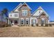 Stunning two-story home boasts a stone facade, gabled roof and a manicured lawn at 4205 Madison Hall Dr, Cumming, GA 30028