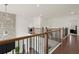 Second floor hallway with hardwood floors, wooden handrail, and wrought iron spindles at 4205 Madison Hall Dr, Cumming, GA 30028