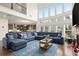 Open-concept living room boasts a large sectional sofa, tall windows, and hardwood floors at 4205 Madison Hall Dr, Cumming, GA 30028