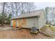 Exterior view of back of home with boarded doors, gray siding, and a visible HVAC unit at 2370 Wingfoot Pl, Decatur, GA 30035