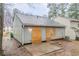 Exterior back of home with boarded up doors, concrete patio and muddy ground at 2370 Wingfoot Pl, Decatur, GA 30035