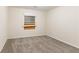 Bedroom with neutral paint and carpet, featuring a window covered with plywood at 2370 Wingfoot Pl, Decatur, GA 30035