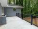 View of the patio of a painted brick house with black railing and lush greenery in the background at 2899 Tejas Sw Trl, Atlanta, GA 30331