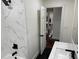 Bathroom showing white marble tile and black fixtures, with a glimpse into the home's interior at 2899 Tejas Sw Trl, Atlanta, GA 30331