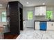 Bright kitchen with white cabinets, black brick accent, and marble floors at 2899 Tejas Sw Trl, Atlanta, GA 30331