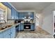 Charming kitchen with painted blue cabinets, stainless steel appliances, and tiled backsplash at 161 Muddy River Rd, Lawrenceville, GA 30043