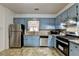 Kitchen featuring painted blue cabinetry, stainless steel appliances, and granite countertops at 161 Muddy River Rd, Lawrenceville, GA 30043