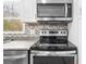 Stainless steel microwave and black range sit atop granite countertops with stylish herringbone backsplash at 2923 Hall Se Dr, Smyrna, GA 30082