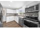 Modern kitchen featuring white cabinetry, stainless steel appliances, and a stylish gray backsplash at 2923 Hall Se Dr, Smyrna, GA 30082