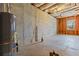 Unfinished basement showing water heater, pipes, and concrete foundation at 4263 Winslow Hill Ct, Suwanee, GA 30024