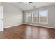 Bedroom featuring vaulted ceilings, wood-look floor, and three large windows at 4263 Winslow Hill Ct, Suwanee, GA 30024