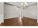 Elegant dining room featuring dark hardwood floors, neutral wall colors, decorative molding, and modern chandelier at 4263 Winslow Hill Ct, Suwanee, GA 30024