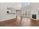 Bright living room with hardwood floors, a fireplace, large windows, and access to a modern kitchen at 4263 Winslow Hill Ct, Suwanee, GA 30024