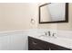 This is a bathroom featuring a dark wood vanity with a white countertop and framed mirror above at 3775 Norman Rd, Clarkston, GA 30021
