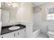 Modest bathroom with white vanity, mirror, tub with shower and white-painted wainscoting at 3775 Norman Rd, Clarkston, GA 30021