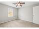 Neutral bedroom with carpeted floors, ceiling fan, a window, and a white door at 3775 Norman Rd, Clarkston, GA 30021