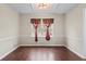 Classic dining room featuring hardwood floors, chair rail, and a window with decorative curtains at 3775 Norman Rd, Clarkston, GA 30021