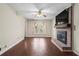 Bright living room with brick fireplace, hardwood floors, ceiling fan, and large window at 3775 Norman Rd, Clarkston, GA 30021