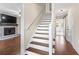 Bright foyer features staircase with hardwood treads, connecting to living room with brick fireplace at 3775 Norman Rd, Clarkston, GA 30021