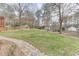 Expansive backyard featuring a lush lawn, stone pathway, and a backdrop of mature trees at 3852 Old Bridge Way, Duluth, GA 30096